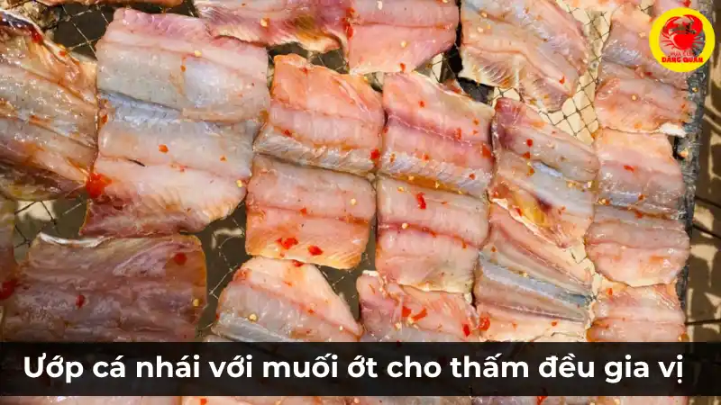 Ướp cá nhái đã sơ chế với hỗn hợp muối ớt đậm đà để cá thấm đều gia vị trước khi nướng