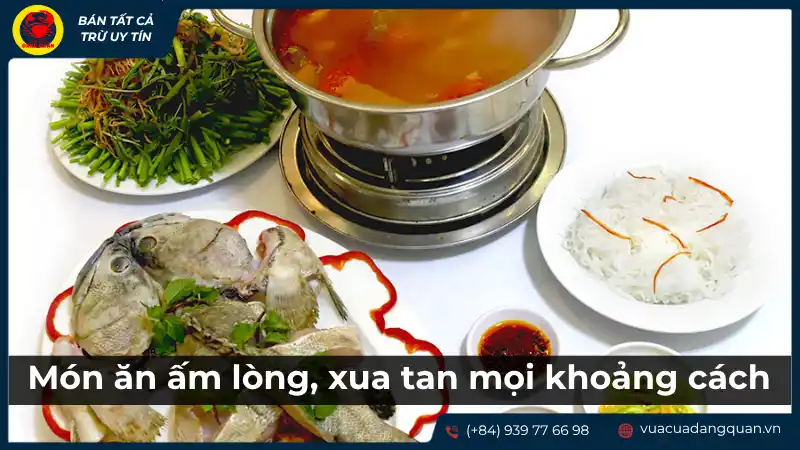 Bàn ăn với nồi lẩu cá mú măng chua đang sôi và các món nhúng kèm như rau sống, bún, gợi cảm giác ấm cúng, sum vầy.